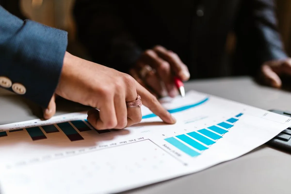 Deux professionnels analysant un graphique de résultats en hausse lors d'une réunion