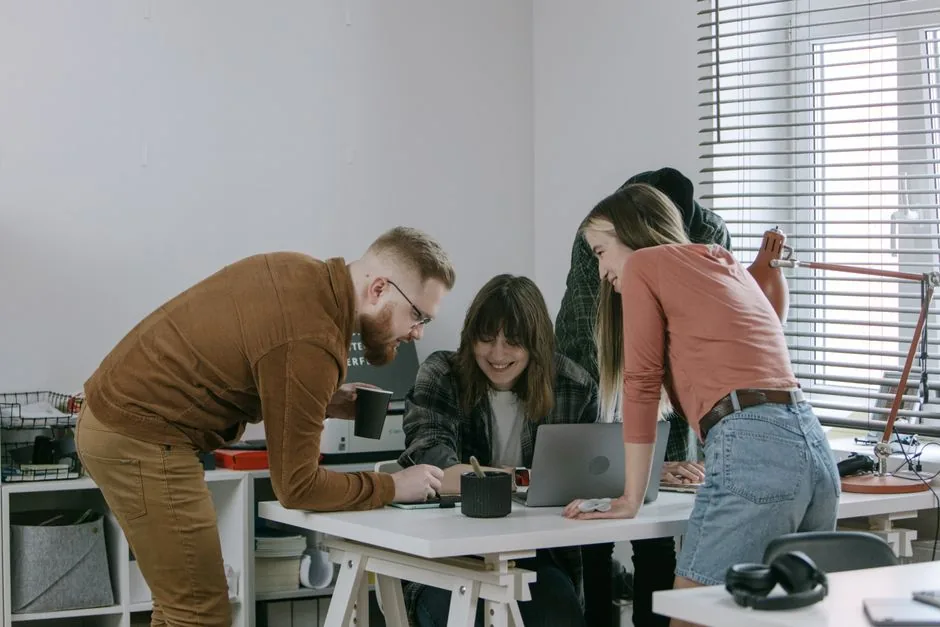 Équipe créative collaborant autour d'un ordinateur dans un bureau