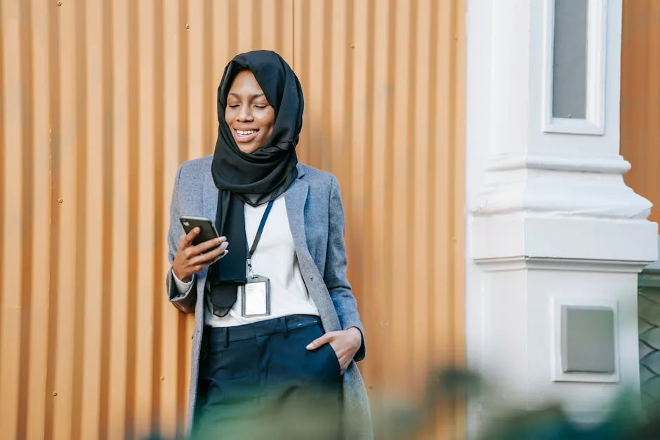 Femme professionnelle souriante consultant son smartphone en extérieur